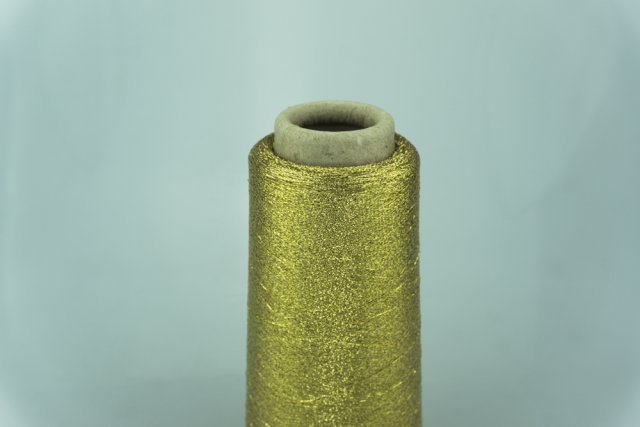 ILARIA S.R.L. CALENZANO Art. BRILLANTE Col. 908 ORO ( Золото ) Состав: 50% Полиамид (PA), 50% Полиэстер ( PL ). Метраж пряжи: 10000м/100гр. ( 100000 )